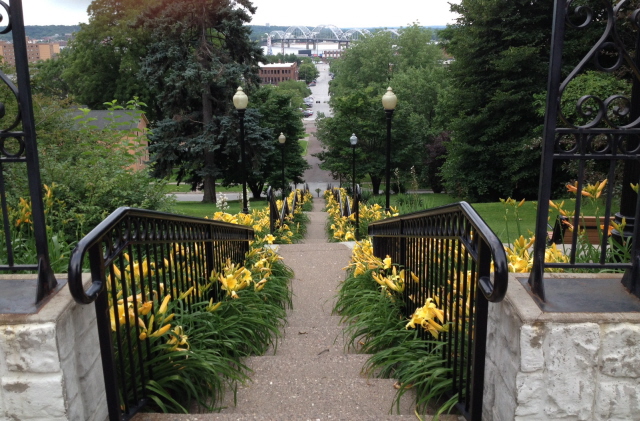 Stairs, lined with yellow daylilies, leading down to the river in Davenport, Iowa